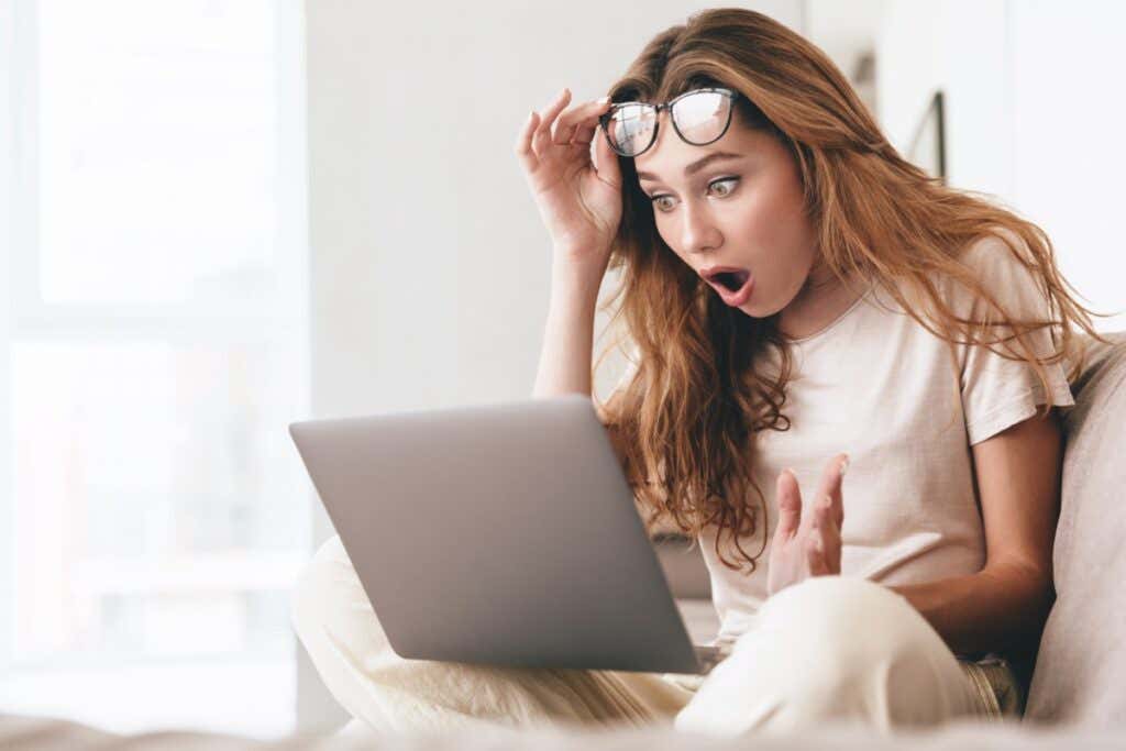 woman looking shocked at what she is seeing on her computer