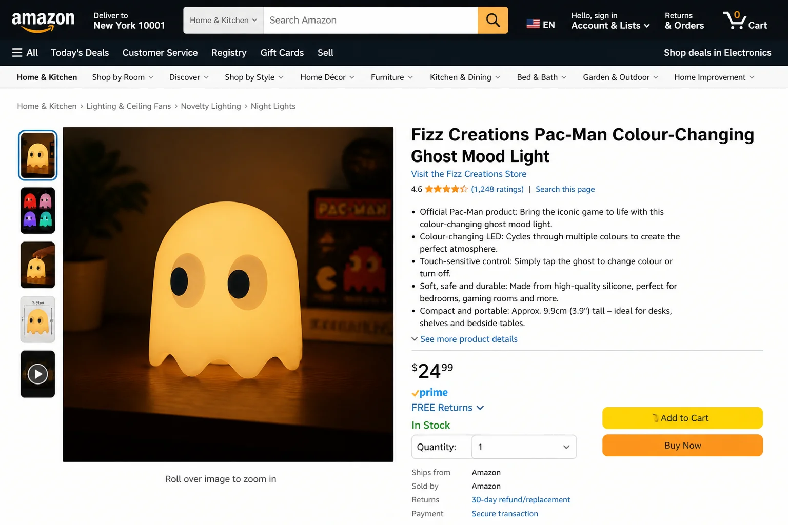 Pac-Man themed lamp lit up showing the iconic ghost-chasing character design casting a warm ambient glow in a dim room